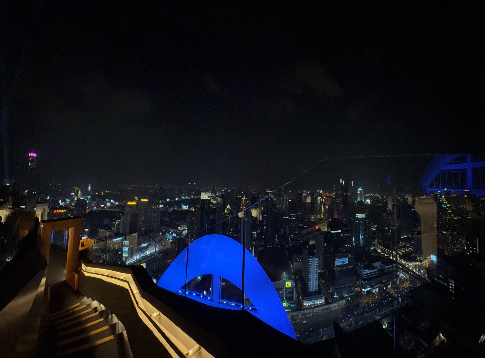 The glowing blue dome of Red Sky seen at night above Bangkok
