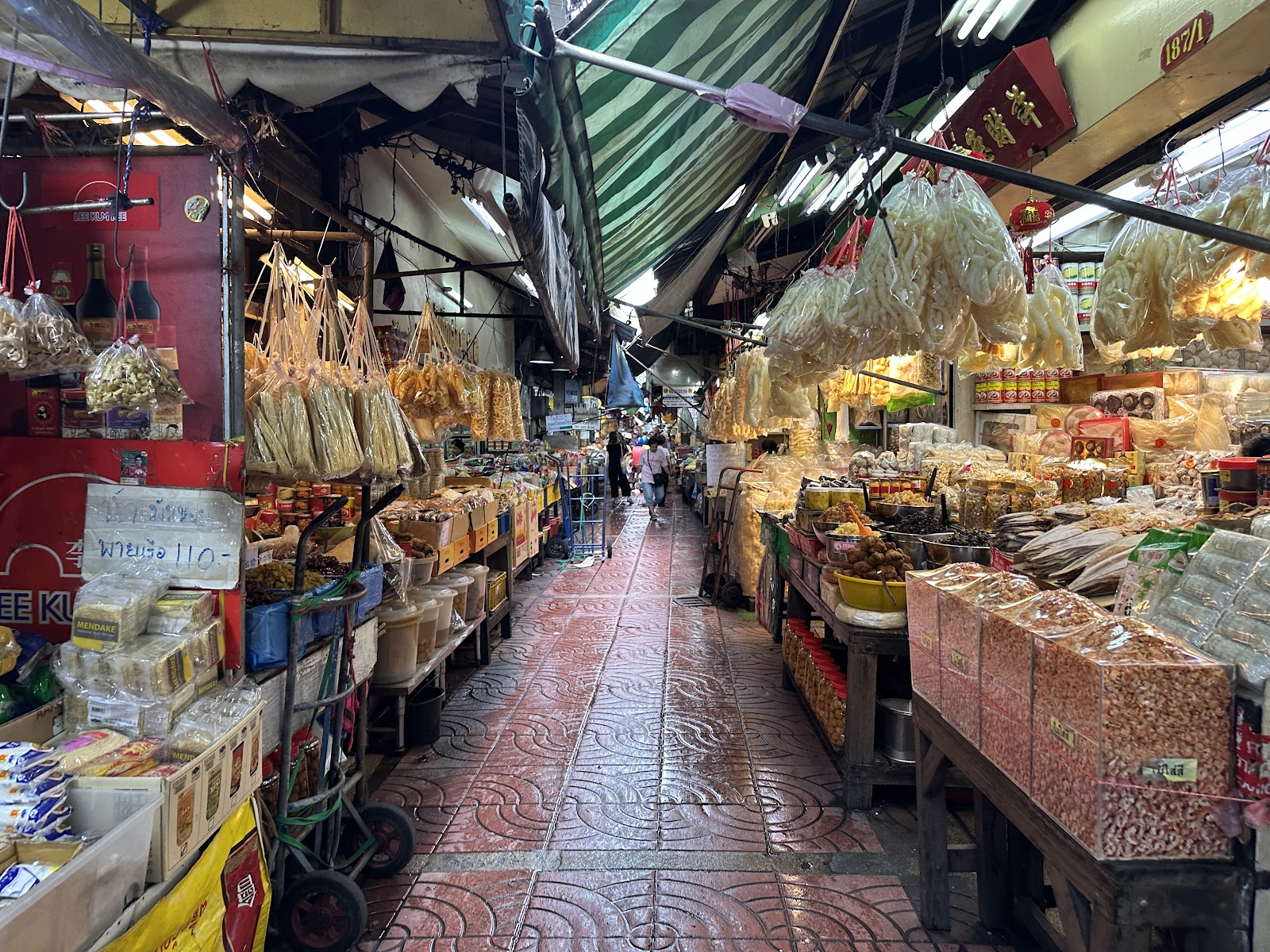 A covered lane in Bangkok's Chinatown lined with shops selling dried goods in sacks and boxes