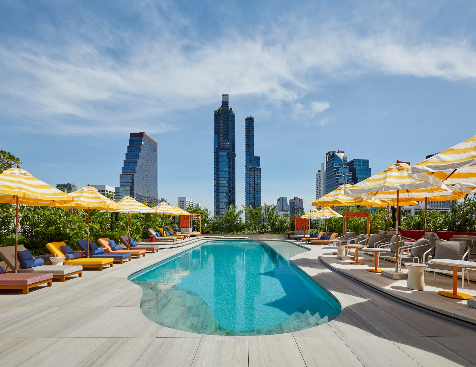 The pool deck at The Standard, Bangkok Mahanakhon with yellow umbrellas and the Bangkok skyline
