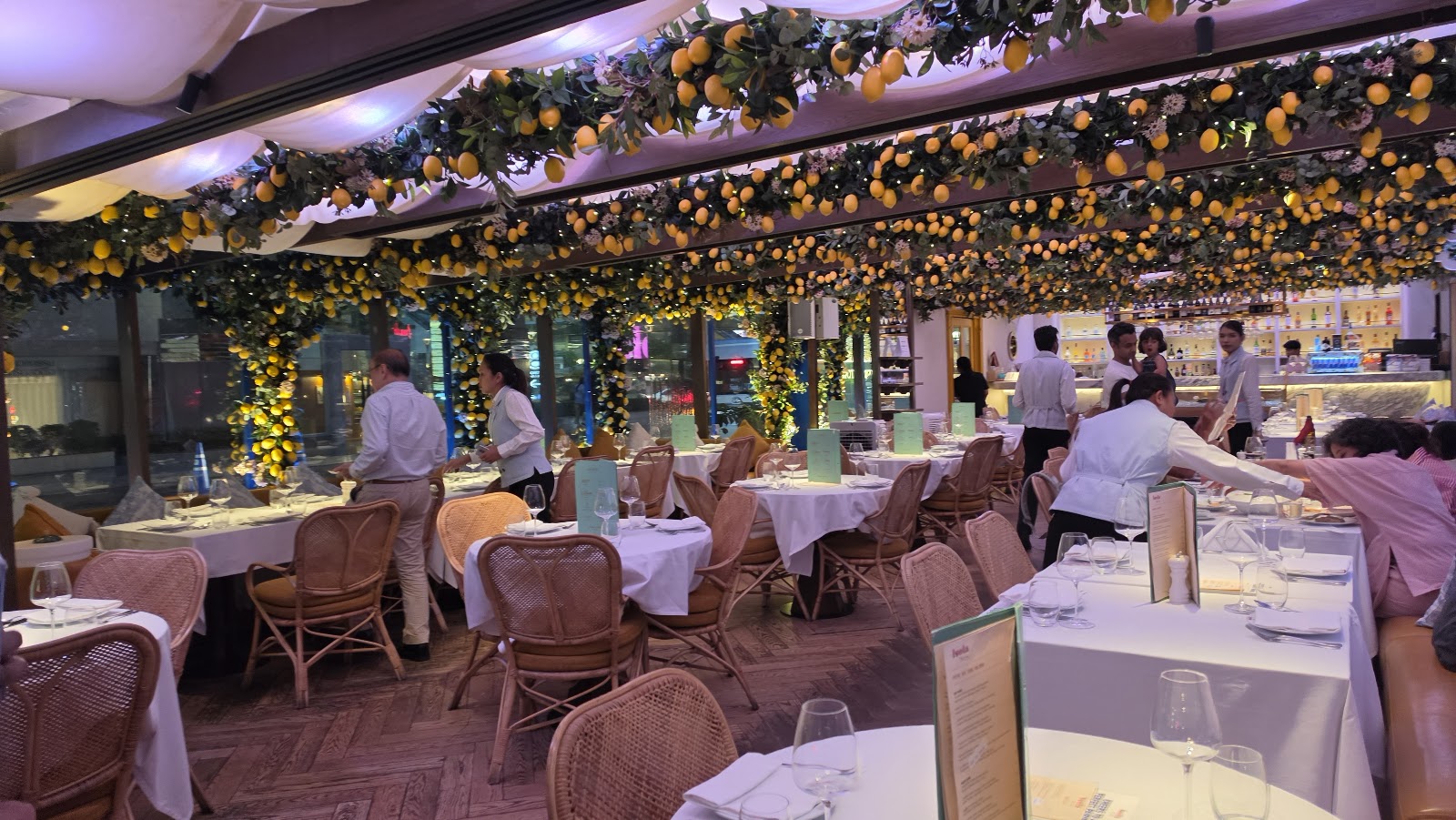 The dining room at Isola by Signor Sassi with lemon branches hanging over the tables