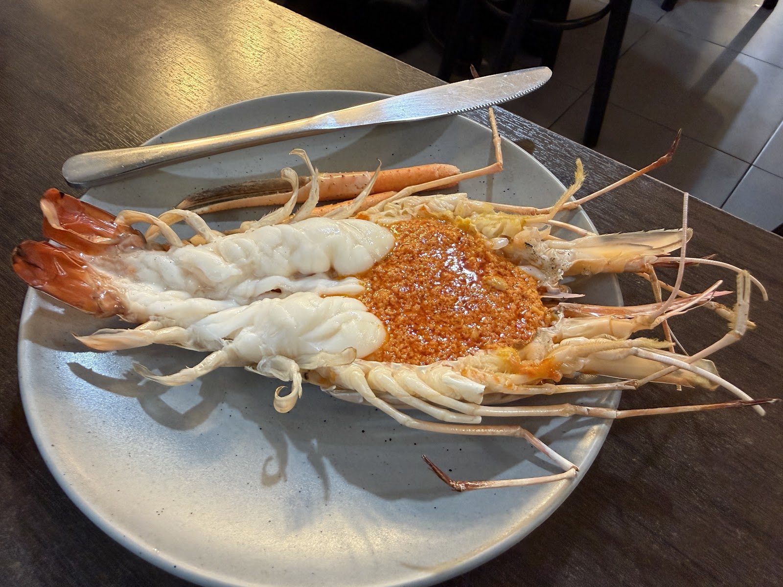 Grilled giant river prawns split open on a plate at Here Hai