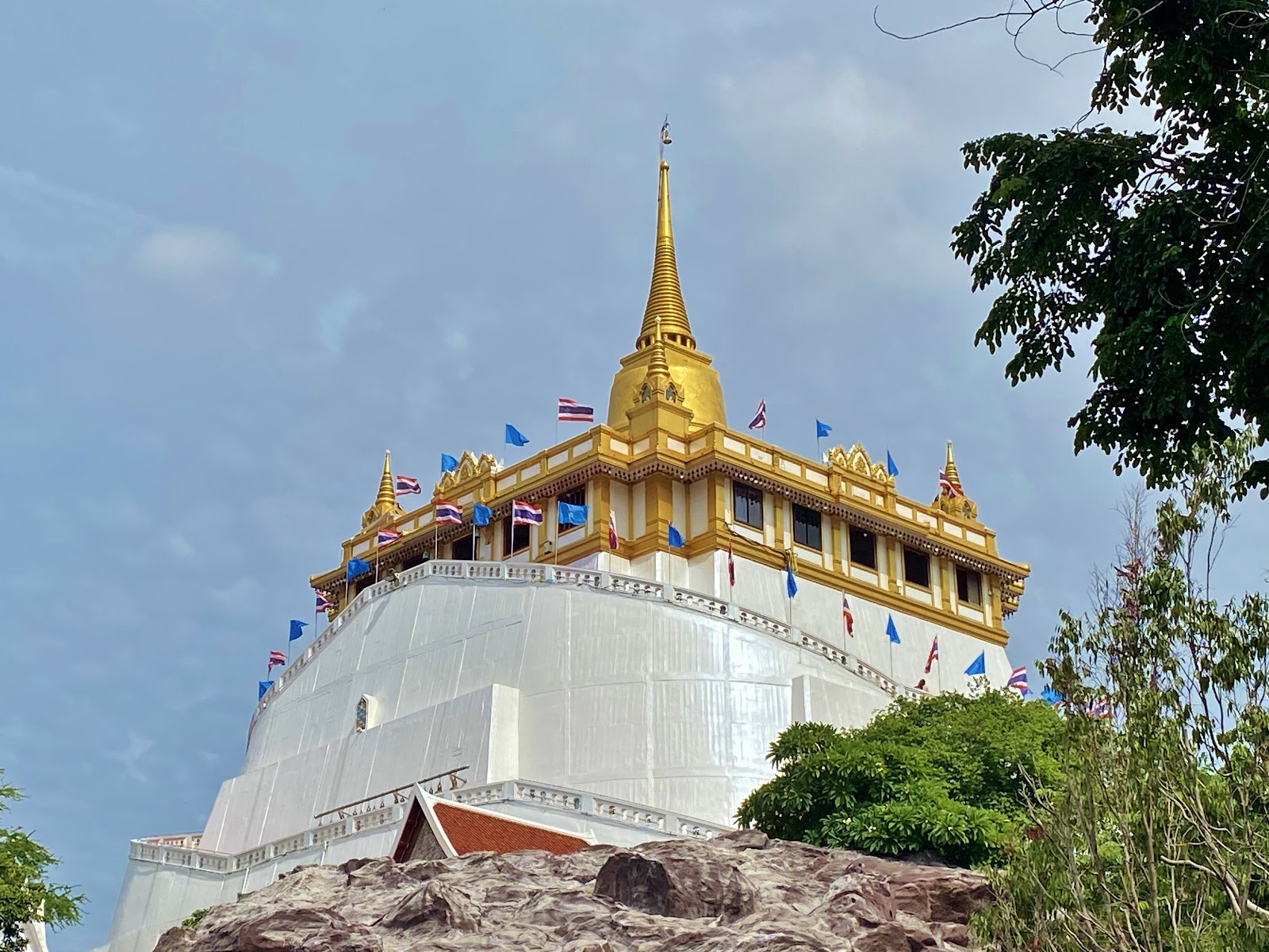 The golden chedi on top of the whitewashed Golden Mount at Wat Saket, framed by trees