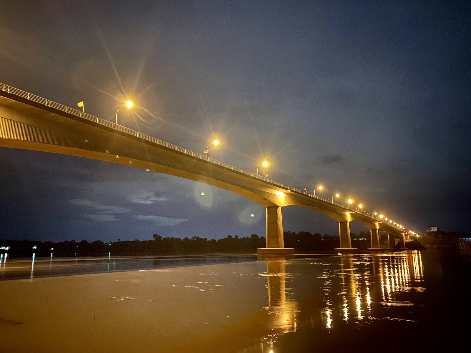 The First Thai-Lao Friendship Bridge lit by streetlights at night, reflected in the Mekong River