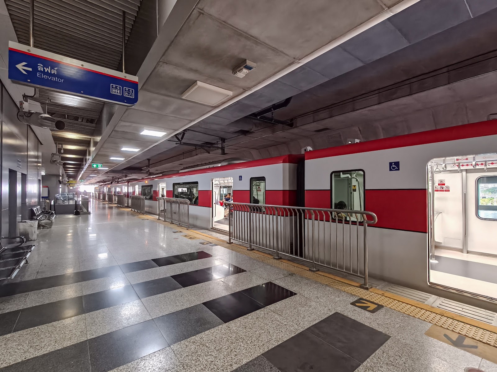 A red and white SRT Red Line train at a platform in Krung Thep Aphiwat Central Terminal