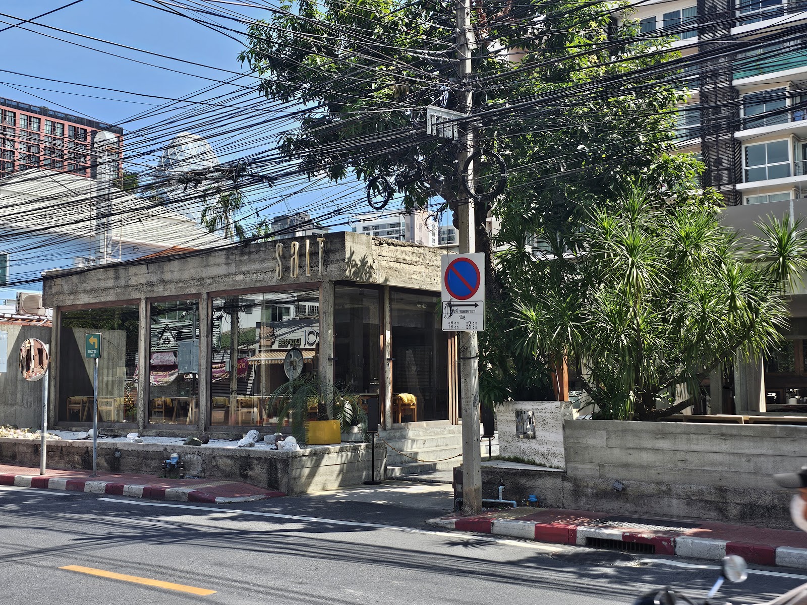 The glass-fronted restaurant Salt on a tree-lined lane in Ari