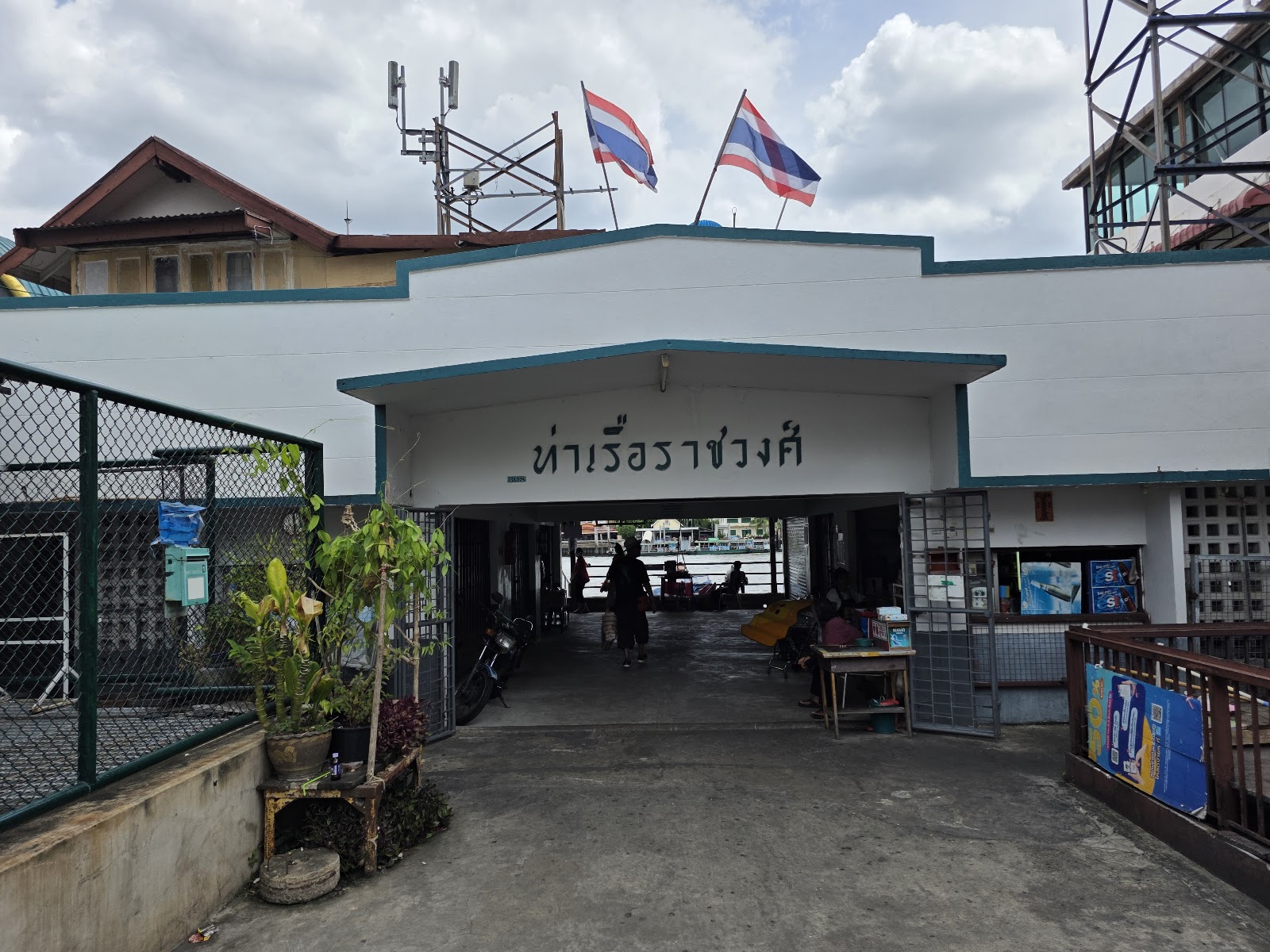 Entrance to Ratchawong Pier with its Thai name sign and flags