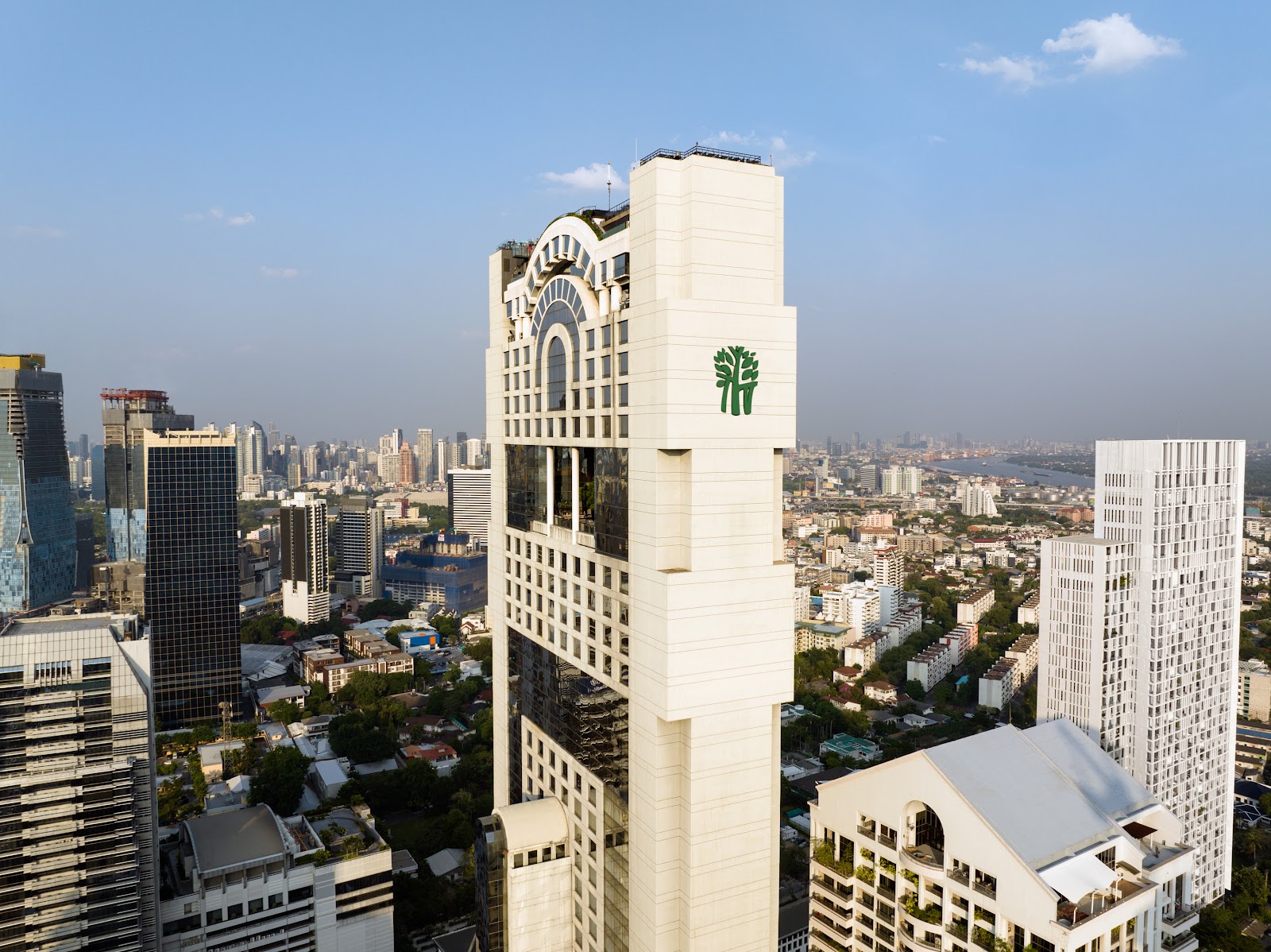 The slim white Banyan Tree Bangkok tower rising among office buildings in Sathorn