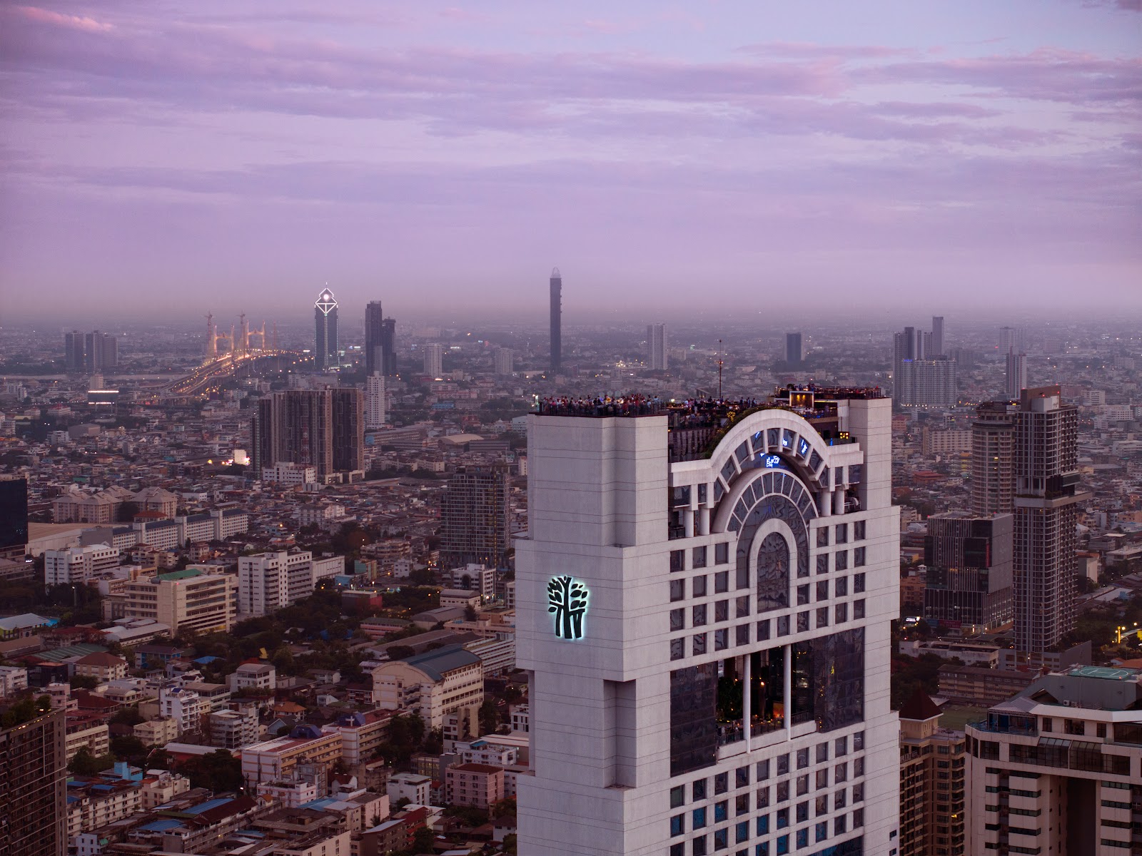 The top of the Banyan Tree Bangkok tower against the city skyline at dusk