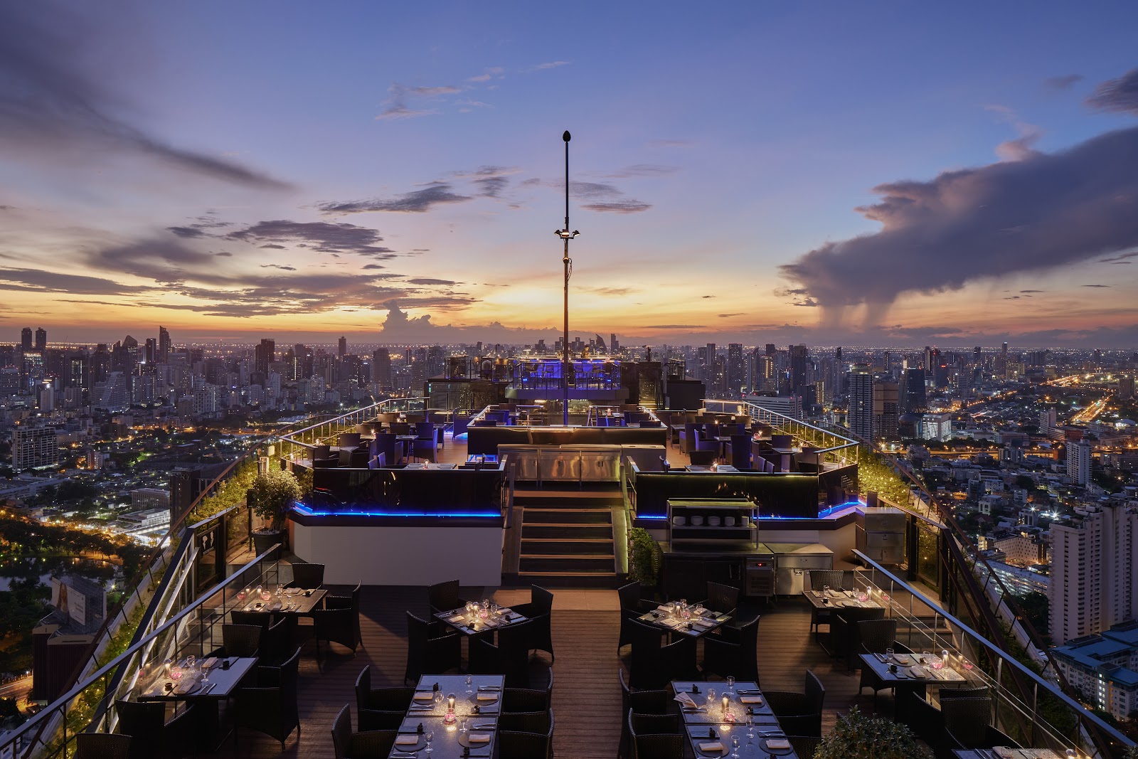 The open-air Vertigo rooftop deck at dusk with the city lights below