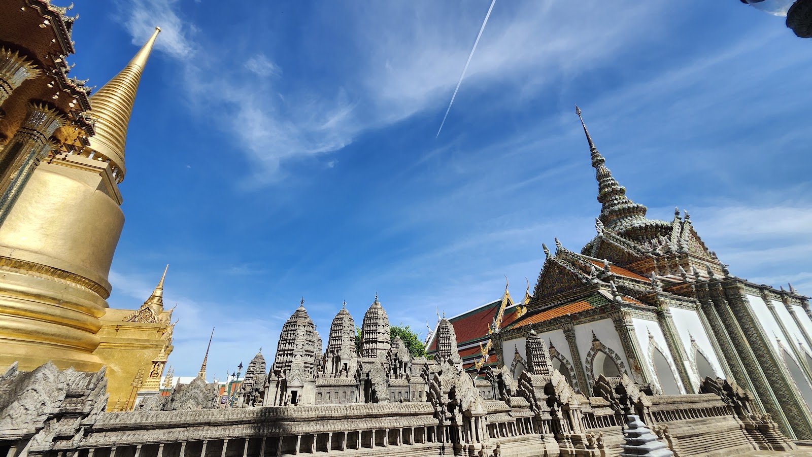 The stone model of Angkor Wat beside a gilded chedi on the terrace of the Temple of the Emerald Buddha